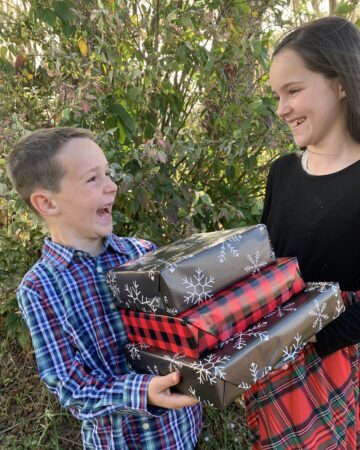 boy and girl holding gifts and laughing
